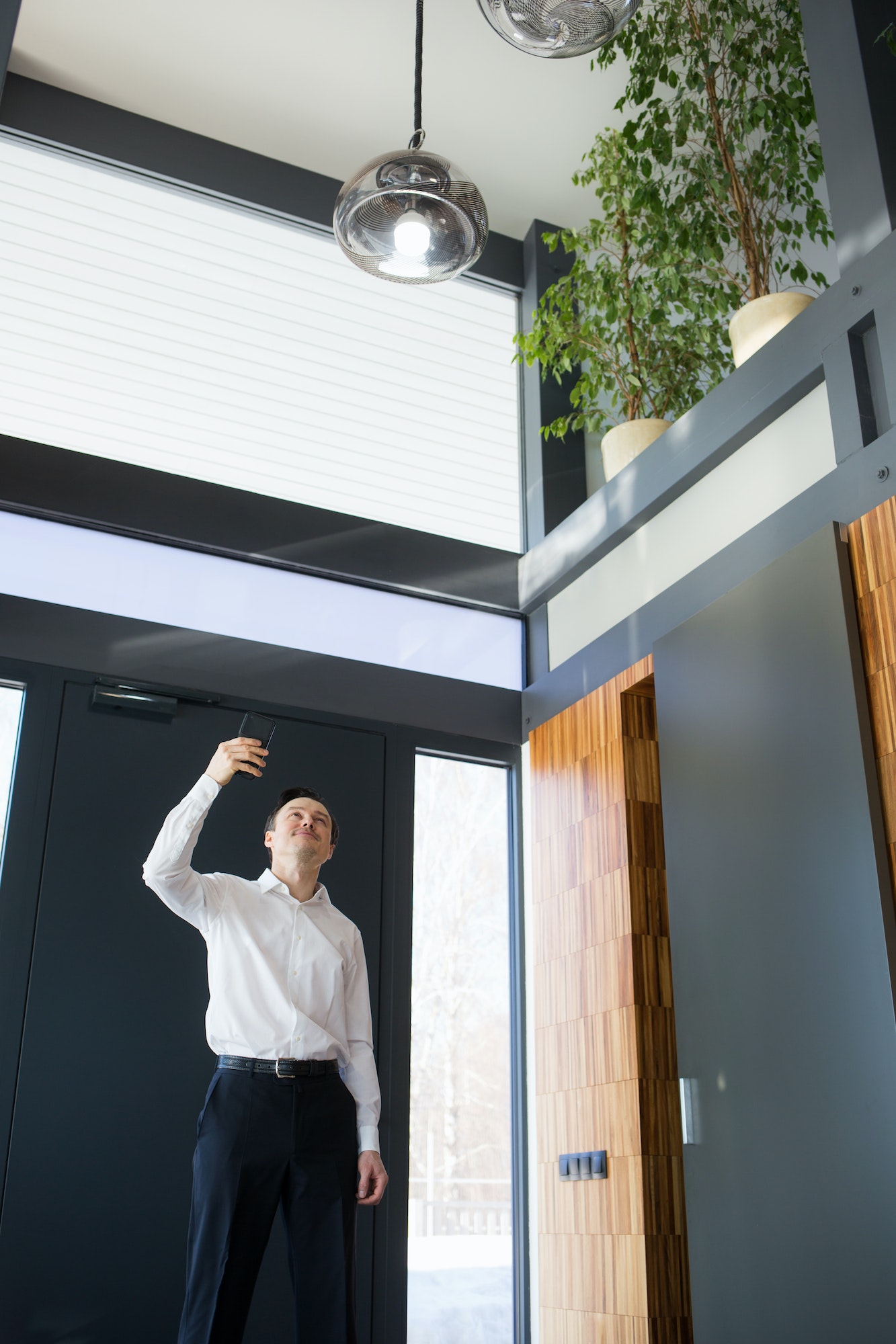 Man controlling home light with digital tablet in his house.